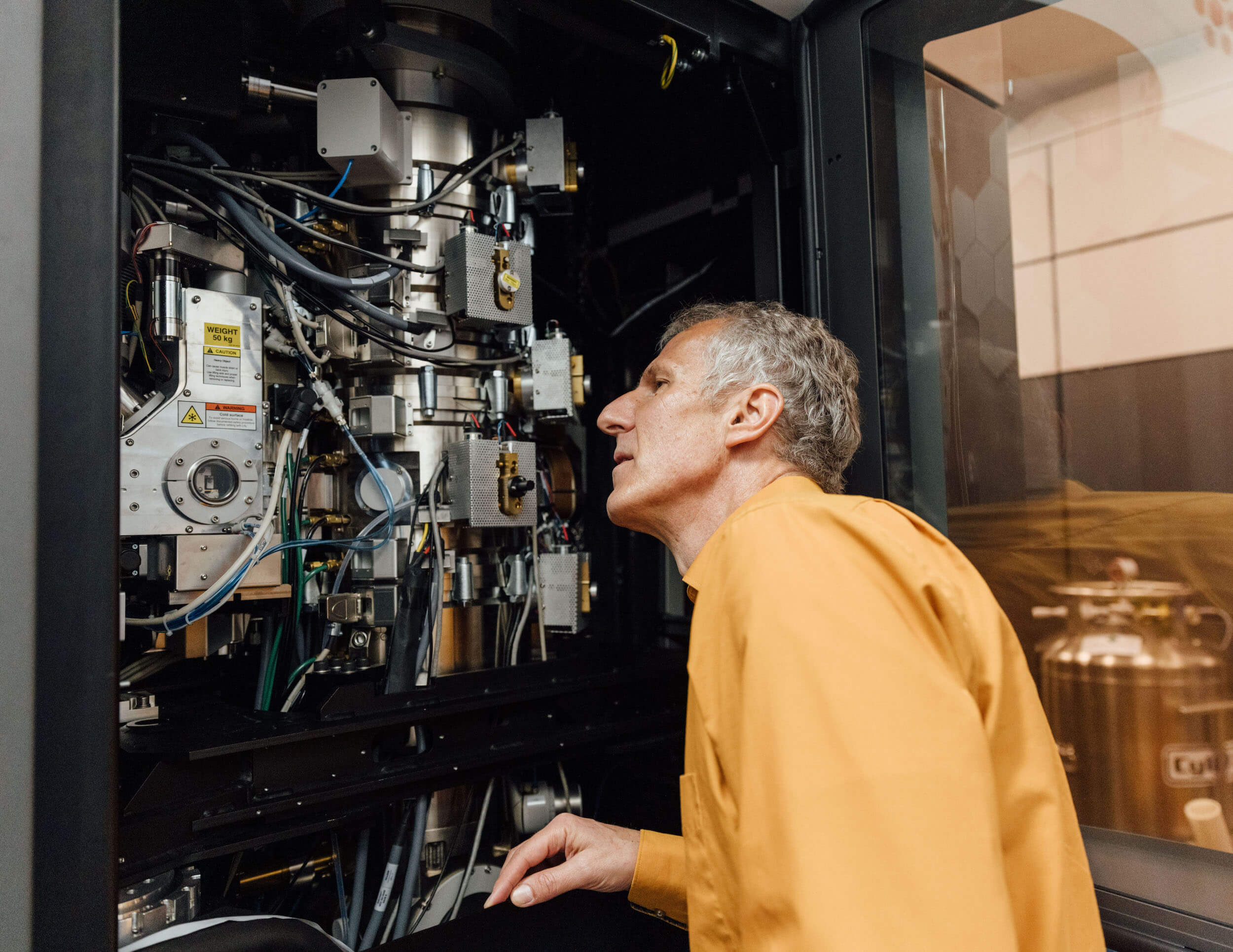 Matthias Haury, Acting Executive Director and Chief Operating Officer of the Chan Zuckerberg Institute for Advanced Biological Imaging, looks inside of a Krios microscope.
